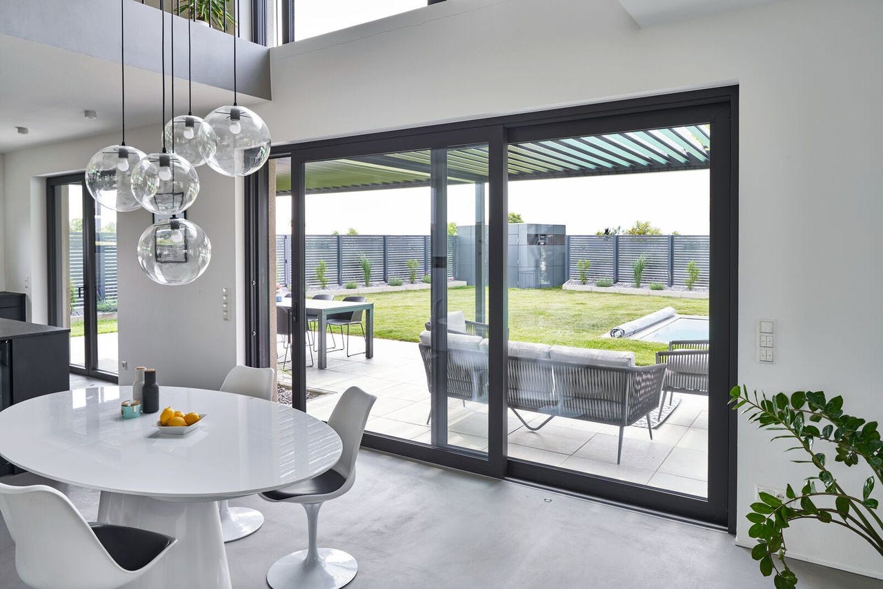 Modernes Deceuninck Schiebefenster schlankem Rahmen und Blick auf Terrasse und Garten
